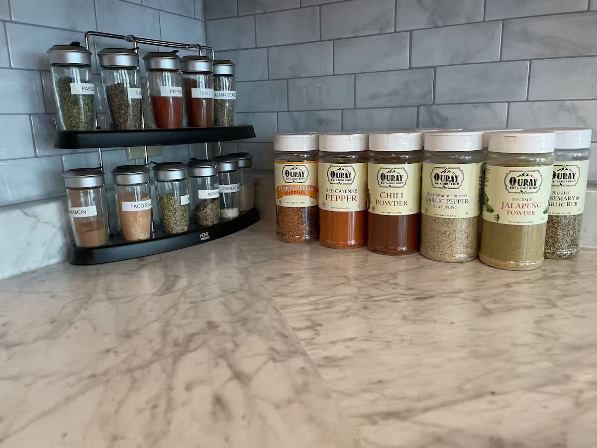 Spice rack and jars of seasoning from the Ouray Meat & Cheese Market on the kitchen counter