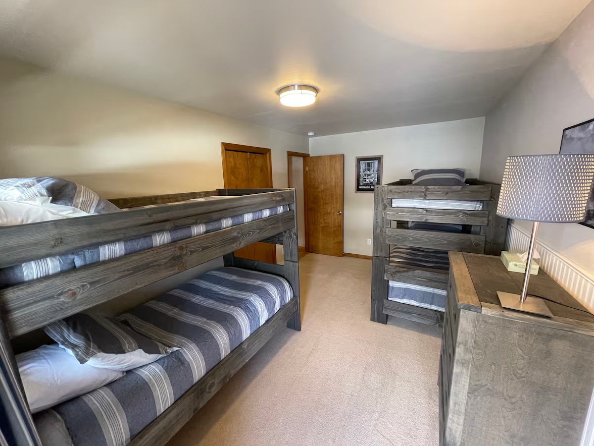 Bunk room with two sets of bunk beds and a dresser